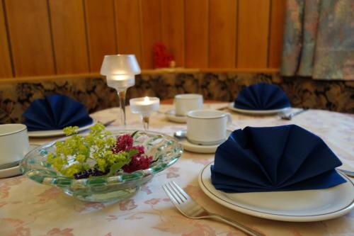 una mesa con platos y un tazón de flores. en Gästehaus Daurer en Reinsberg