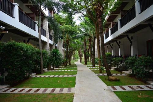 une passerelle devant un bâtiment planté de palmiers dans l'établissement Marina Villa, à Lamai