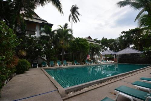 uma piscina com espreguiçadeiras e um resort em Marina Villa em Lamai