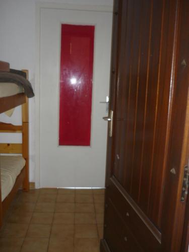 une chambre avec une porte ornée d'une peinture rouge sur le mur dans l'établissement Studio CARQUEIRANNE, à Carqueiranne
