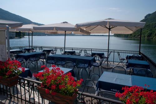 a restaurant with tables and chairs and umbrellas at Hotel Due Palme in Mergozzo