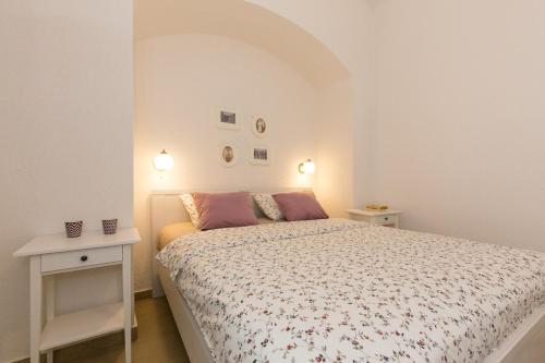 a small bedroom with a bed and two tables at Villa Belsito in Lovran