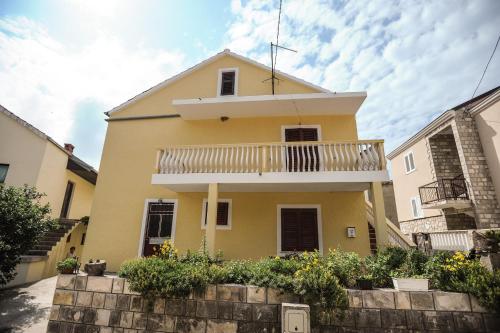 a yellow house with a balcony at Apartments Phoenix in Ivanica