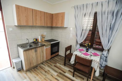 a kitchen with a table and a sink and a table and a window at Apartments Phoenix in Ivanica