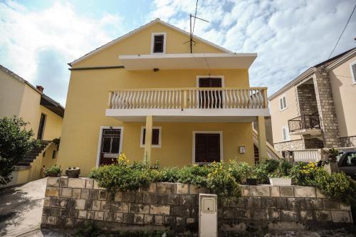 a yellow house with a balcony on top at Apartments Phoenix in Ivanica