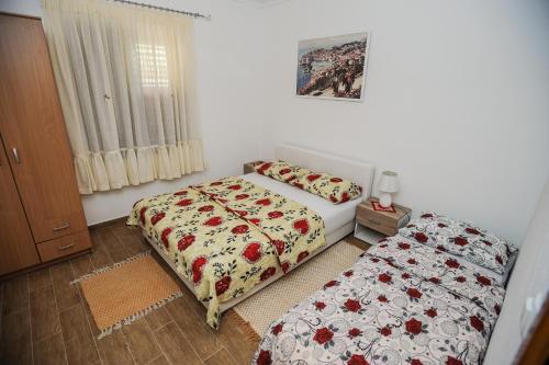 1 dormitorio con 2 camas y ventana en Apartments Phoenix, en Ivanica