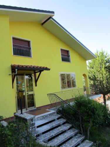 a yellow house with stairs in front of it at Casa Balducci Bed&Breakfast in Mercatello sul Metauro