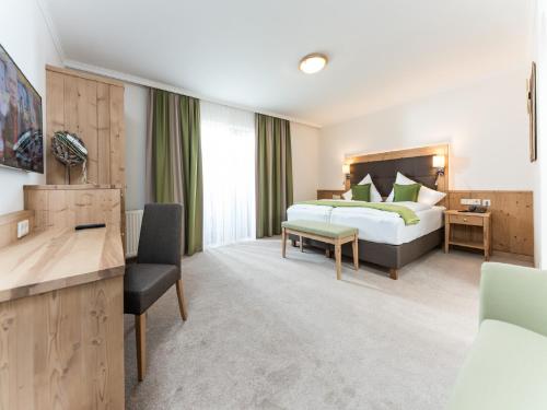 a hotel room with a bed and a desk at Vitalhotel Marienhof in Velden am Wörthersee