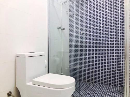 uma casa de banho com um WC e uma cabina de duche em vidro. em Hostel Flor de Maria em São Paulo