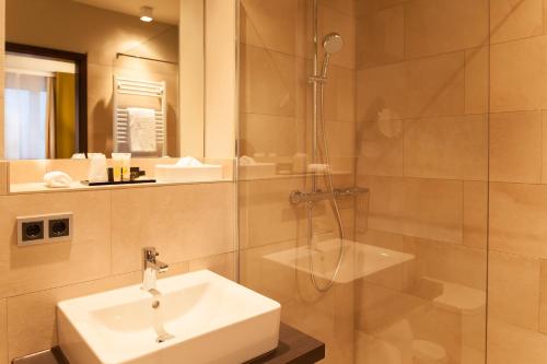 a bathroom with a sink and a shower at Hotel Platzhirsch in Fulda