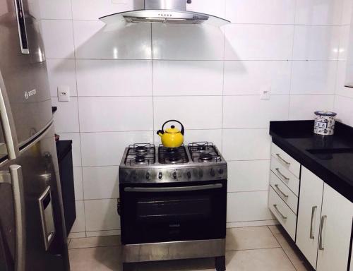 a yellow tea kettle on a stove in a kitchen at Hostel Flor de Maria in Sao Paulo