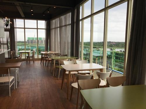 a restaurant with tables and chairs and large windows at The Riverview Retreats in Wujie