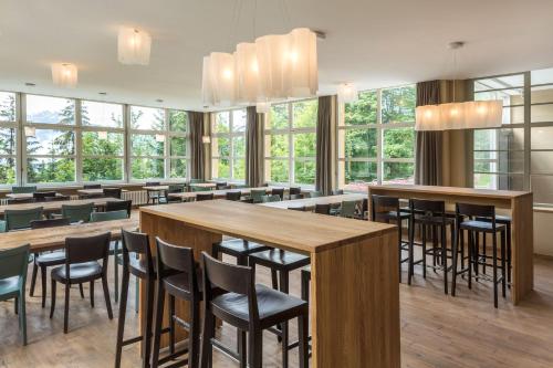 a restaurant with tables and chairs and windows at Crans-Montana Youth Hostel in Crans-Montana