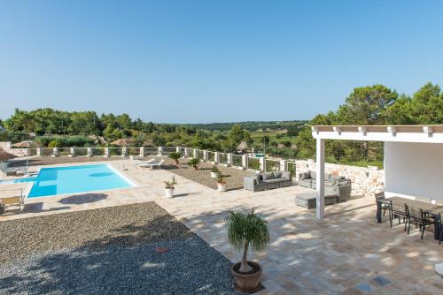 a backyard with a swimming pool and a patio with furniture at Agritrulli in Ostuni