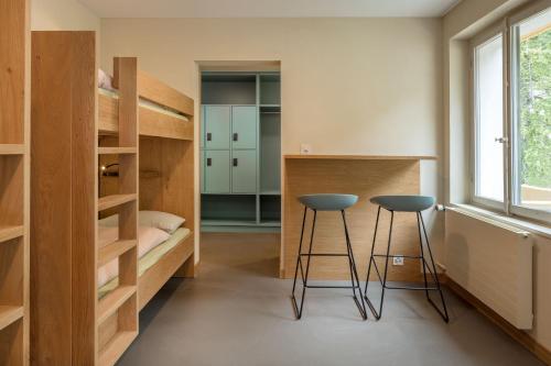 a room with two bar stools and a bunk bed at Crans-Montana Youth Hostel in Crans-Montana