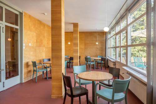 a dining room with tables and chairs and windows at Crans-Montana Youth Hostel in Crans-Montana