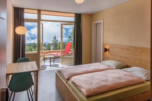 ein Schlafzimmer mit einem Bett und einem Balkon in der Unterkunft Crans-Montana Youth Hostel in Crans-Montana