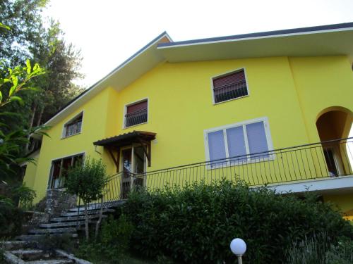 a yellow house with a staircase in front of it at Casa Balducci Bed&Breakfast in Mercatello sul Metauro