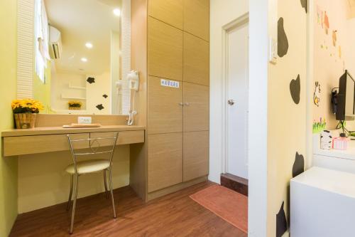 een badkamer met een bureau, een wastafel en een toilet bij Tainan Minuet in Tainan