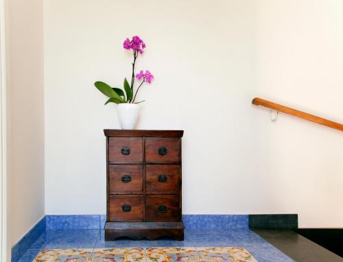 a vase on top of a dresser with a flower on it at Antonio Massa Lubrense in Massa Lubrense