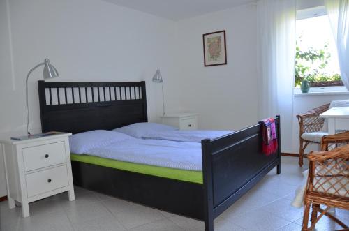 a bedroom with a black bed with a green mattress at Apartmán Srdce Vltavy in Horní Planá