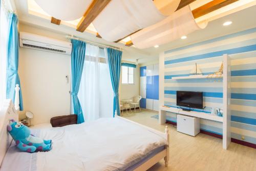 een slaapkamer met een blauwe en witte streepmuur bij Tainan Minuet in Tainan