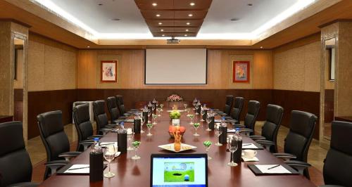 a conference room with a long table and chairs at Savoy Suites Manesar in Gurgaon