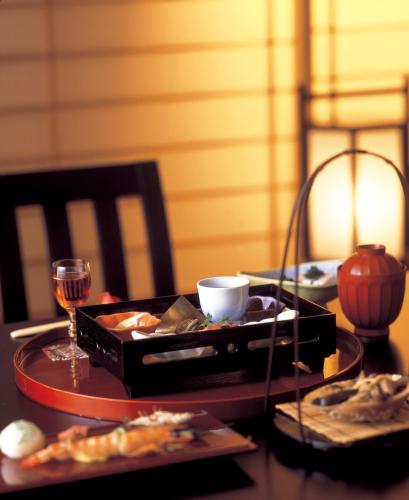 a table with a plate of food and a glass of wine at Maruei in Fujikawaguchiko