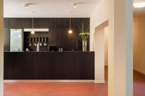 a kitchen with a black counter with a vase of flowers at Crans-Montana Youth Hostel in Crans-Montana