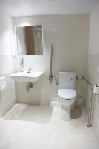 a bathroom with a toilet and a sink and a mirror at Hostal Santel San Marcos in Salamanca