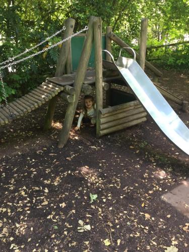 a child in a playground with a slide at Bell Tent Glamping at Royal Victoria Country Park in Southampton