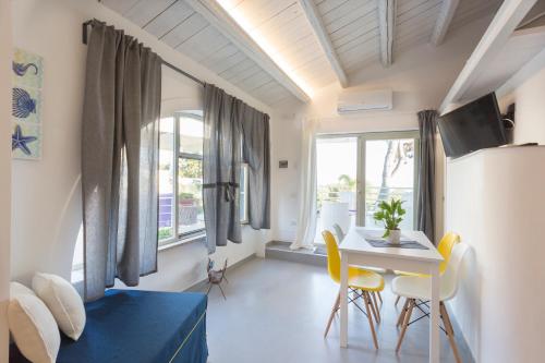 a room with a bed and a table and chairs at Marina Loft Sicily in Marina di Ragusa