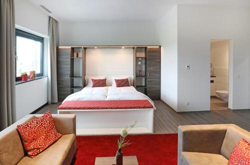 um quarto com uma cama grande e um sofá em 3G Hotel em Fulda