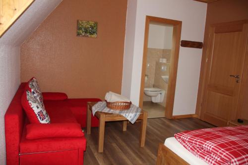 ブルクにあるHaus Lutkiの赤いソファと赤い椅子付きのベッドルーム1室
