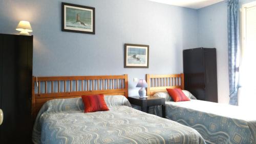 - une chambre avec deux lits et une table avec une lampe dans l'établissement Gîtes sains Baie du mont saint Michel LES HORTENSIAS, à Sains