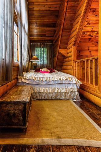 a bedroom with a bed in a log cabin at Sun Moon Lake Full House Resort in Yuchi