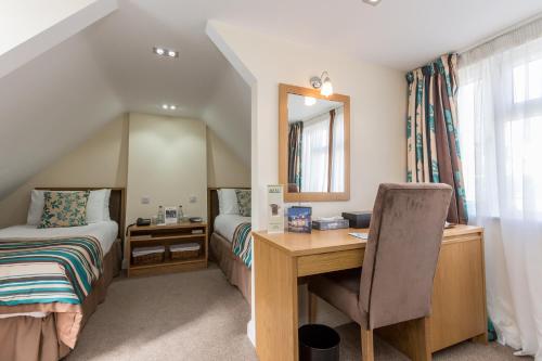 a bedroom with a desk and a bed and a mirror at Best Western Hotel de Havelet in St Peter Port