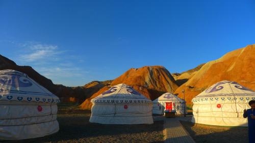 three domes in a desert with mountains in the background at KaoShan Tent Zhangye in Zhangye