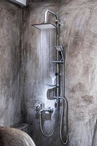 a shower in a bathroom with a shower head at White and Grey in Mikonos