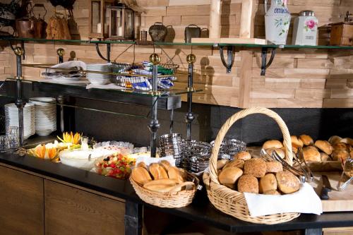 a buffet with baskets of bread and other food at Schmelmer Hof Hotel & Resort in Bad Aibling