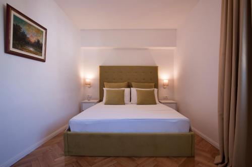 a bedroom with a large bed with two pillows at Apartments Captain's Villa in Budva