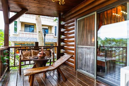 a wooden porch with a table and chairs on a balcony at Sun Moon Lake Full House Resort in Yuchi