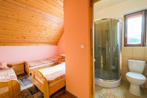 a bathroom with two beds and a shower at Dom Wypoczynkowy Marta in Kacwin