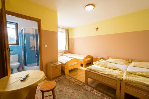 a room with two beds and a bathroom with a shower at Dom Wypoczynkowy Marta in Kacwin