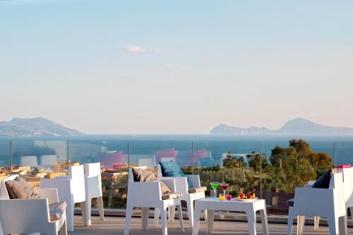 a row of chairs and tables on a balcony with a view at Hotel Marad in Torre del Greco