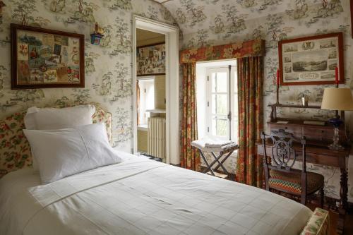 - une chambre avec un lit dans une pièce avec du papier peint dans l'établissement La Marcotte - Pierres d'Histoire, à Saint-Martin-en-Bière