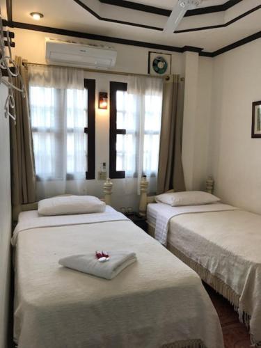 a room with two beds and two windows at View Khemkhong Guesthouse in Luang Prabang