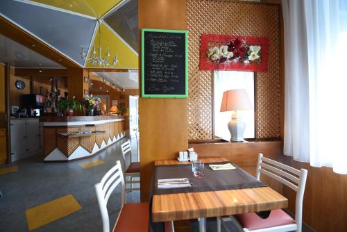 a dining room with a table and a chalkboard at Hôtel Continental in Vierzon