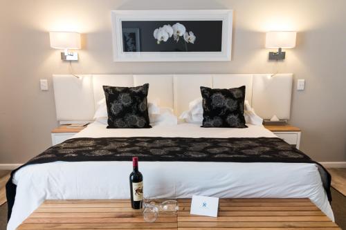 a bedroom with a bed with a bottle of wine on a table at Royal St. Andrews Hotel, Spa and Conference Centre in Port Alfred