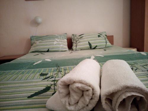 a bedroom with a bed with towels on it at Lile Pestani Accommodation in Peštani